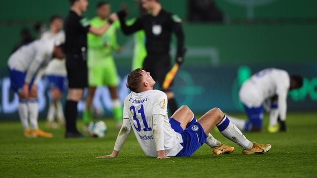 Schalkes Timo Becker sitzt nach dem verlorenen Spiel auf dem Rasen.