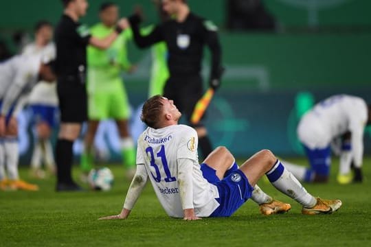 Schalkes Timo Becker sitzt nach dem verlorenen Spiel auf dem Rasen.