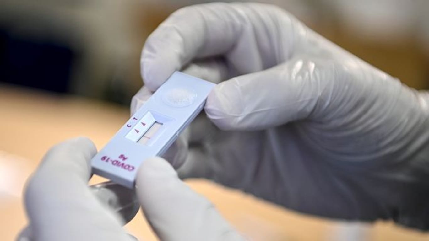 Ein medizinischer Mitarbeiter hält einen negativen SARS-CoV-2-Antigentest (Symbolbild): Einwohner und Pendler können sich in Nürnberg nun kostenlos auf Corona testen lassen.