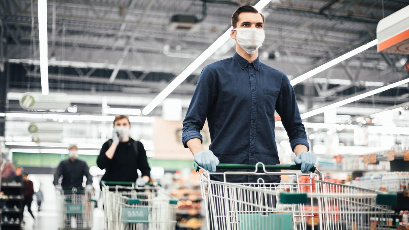 Kunden laufen mit Mundschutzen durch einen Supermarkt (Symbolbild): In Erfurt ist ein Streit um Masken eskaliert.