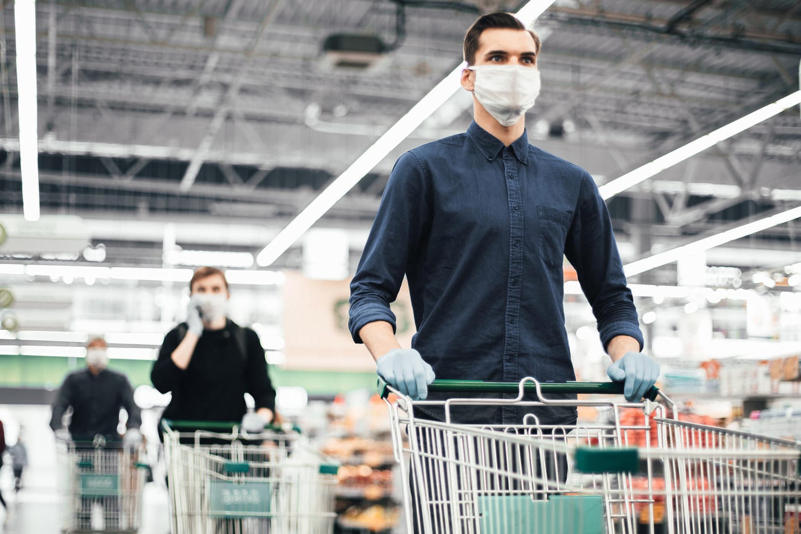 Kunden laufen mit Mundschutzen durch einen Supermarkt (Symbolbild): In Erfurt ist ein Streit um Masken eskaliert.