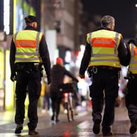 Mitarbeiter des Kölner Ordnungsamtes kontrollieren, dass Personen in der Hohe Straße die dort geltenden Corona-Regeln wi