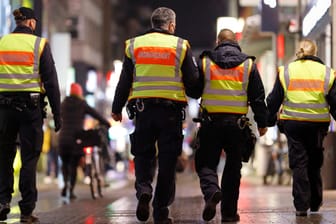 Mitarbeiter des Kölner Ordnungsamtes kontrollieren, dass Personen in der Hohe Straße die dort geltenden Corona-Regeln wi