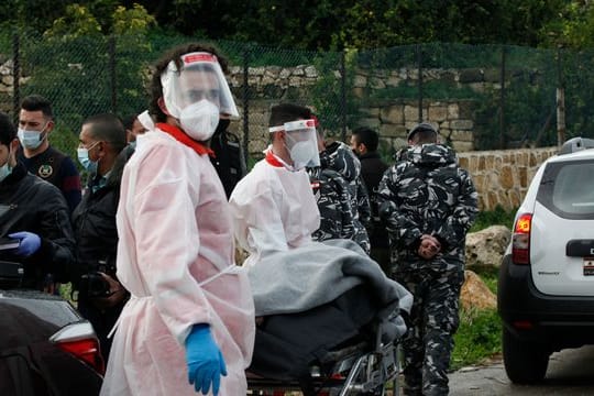 Zwei Mitarbeiter des Libanesischen Roten Kreuzes transportieren den Leichnam Lukman Slim.