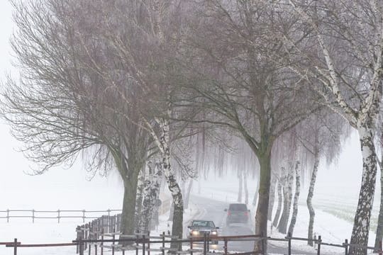 Autos fahren bei leichten Regen über eine Landstraße