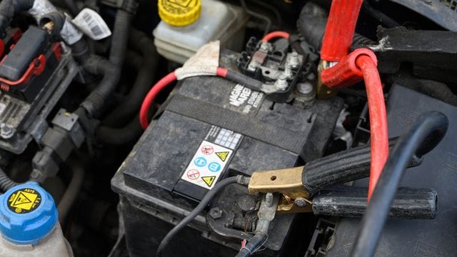 Autobatterie mit Starthilfekabel: Oft bleiben Autos liegen, weil die Batterie entladen ist.