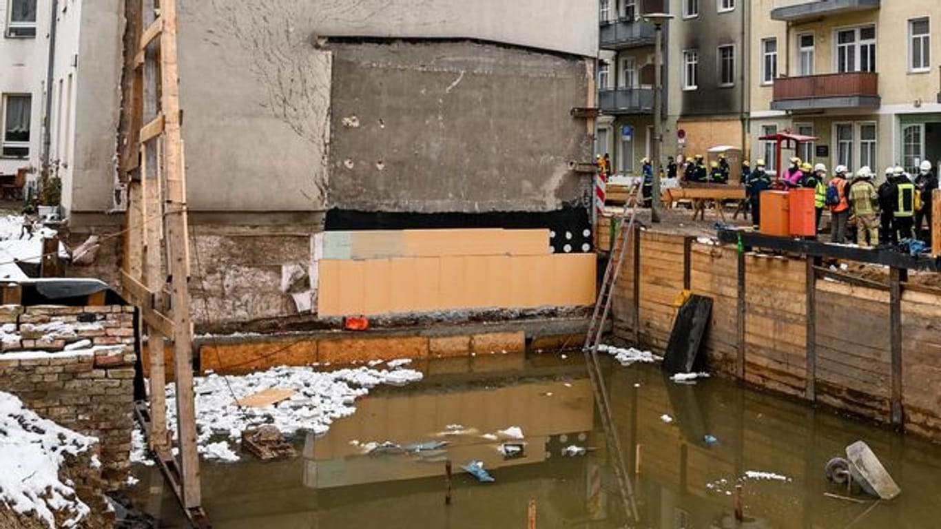 Ein Holzgerüst stützt eine Hauswand: Nach dem Wassereinbruch in einer Baugrube in Berlin-Köpenick mussten viele Anwohner ihre Wohnungen verlassen.