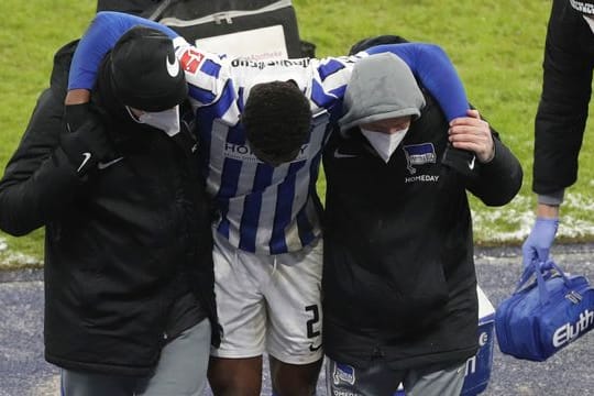 Herthas Jordan Torunarigha (M) wird nach einem Zusammenprall mit Bayerns Leroy Sane vom Platz gebracht.