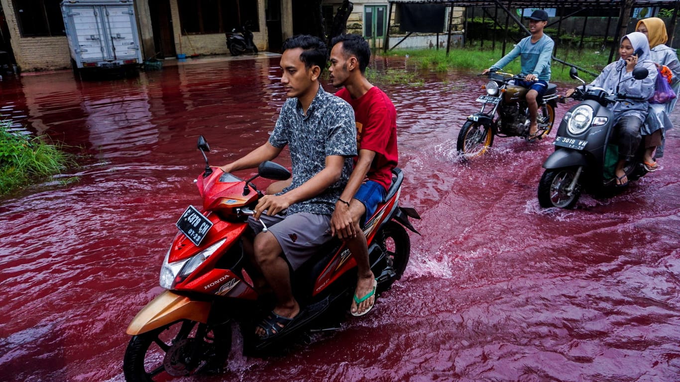 Überschwemmte Straße in Pekalongan: Farbstoffe zum Färben von Kleidung machten den Fluss rot.
