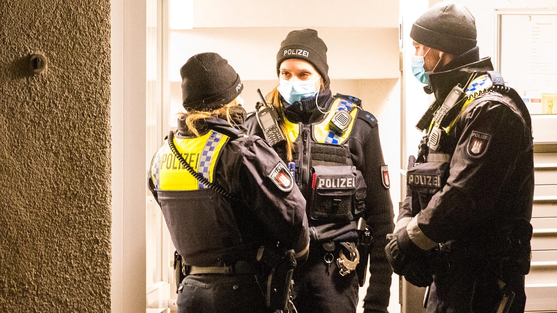 Polizisten stehen im Stadtteil Bramfeld vor einem Mehrfamilienhaus: Die Mordkommission ermittelt gegen einen 28-Jährigen.