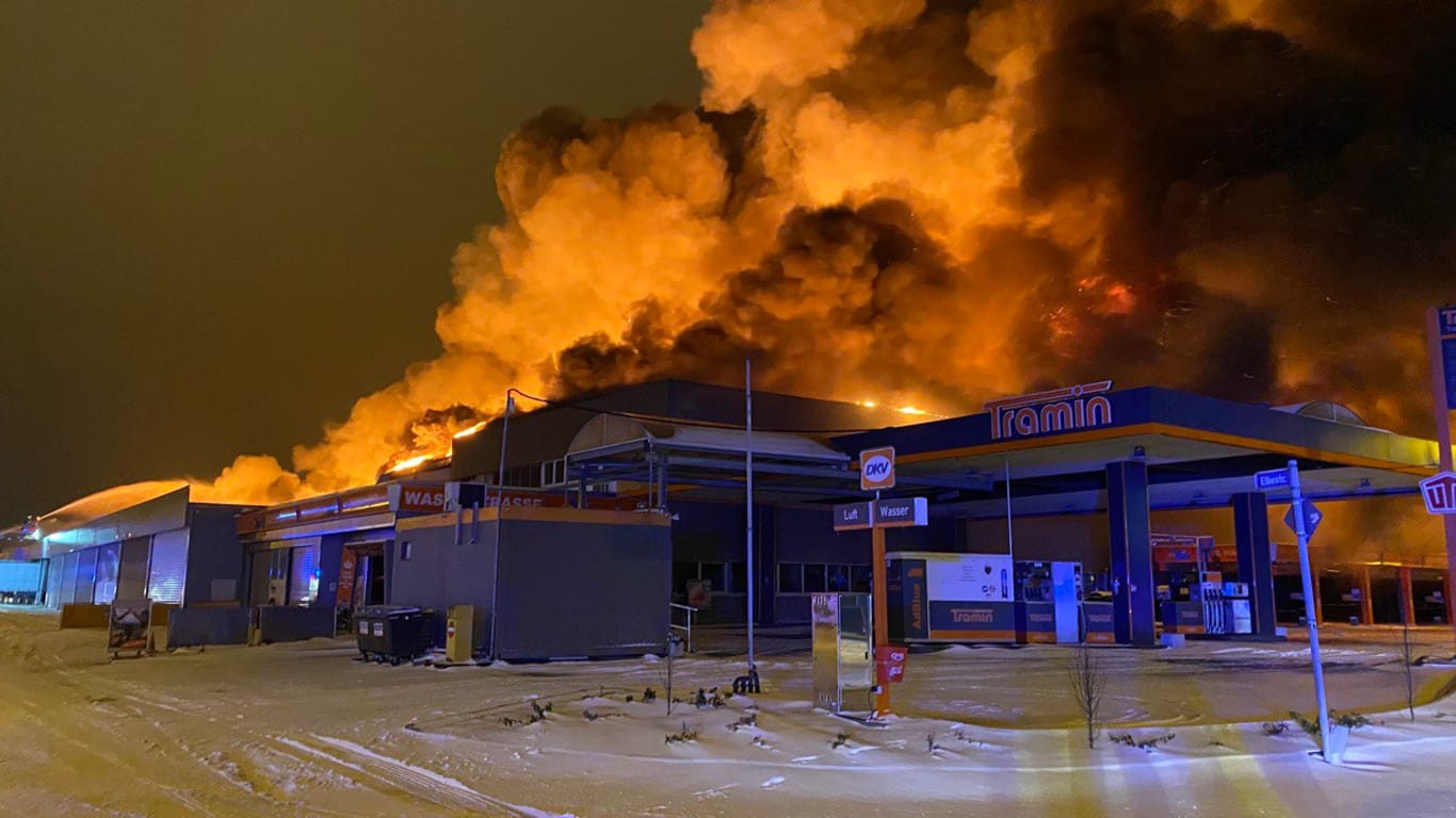Flammen schlagen hoch aus einem Gebäude: Der Großbrand in einem ehemaligen Supermarkt in Mülheim entzündete sich in der Nacht auf Montag in der Nähe einer Tankstelle.