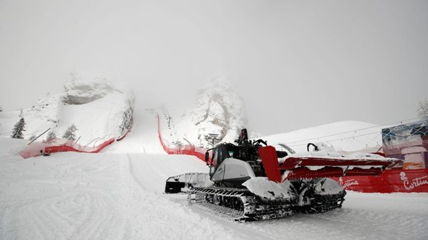 Eine Pistenraupe beseitigt in Cortina d'Ampezzo Neuschnee an der Strecke.