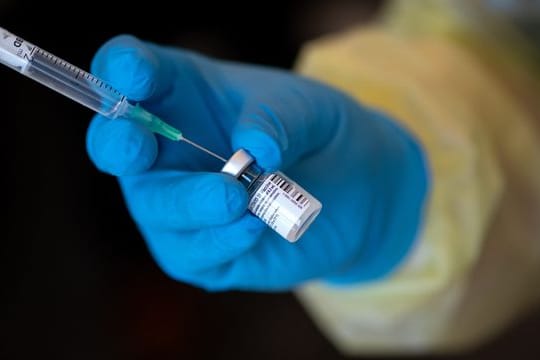 Eine Mitarbeiterin vom Bayerischen Roten Kreuz mit dem Impfstoff von Biontech/Pfizer gegen das Coronavirus SARS-CoV-2.