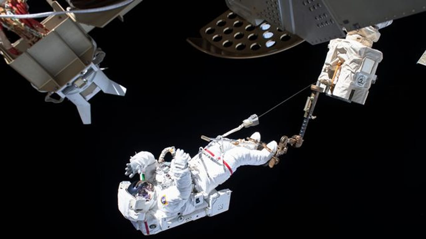 Der ESA-Astronaut Luca Parmitano ist bei einem Außeneinsatz an der Internationalen Raumstation ISS über den Roboterarm Canadarm2 gesichert.