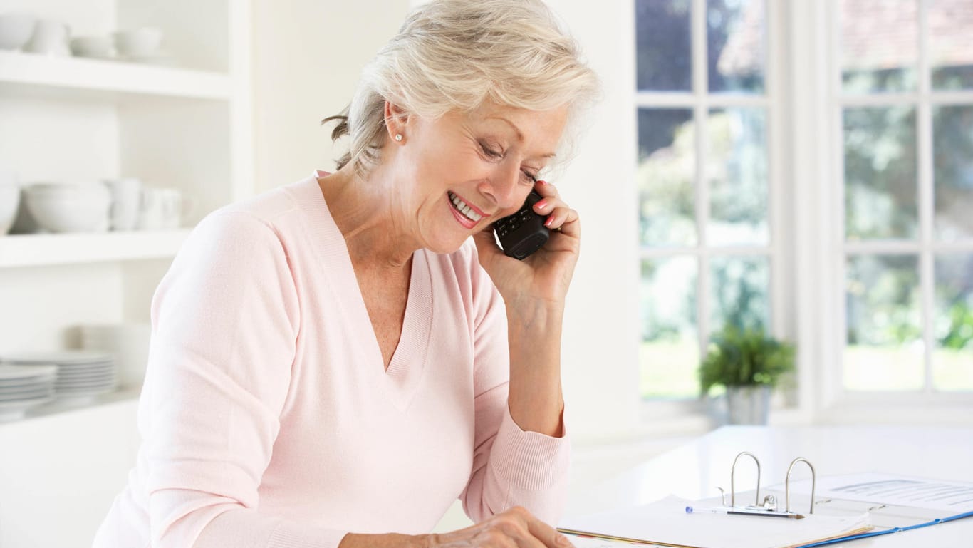 Ältere Frau mit Unterlagen (Symbolbild): Ratenkredite sind für Senioren günstiger als für Durchschnitts-Kreditnehmer.