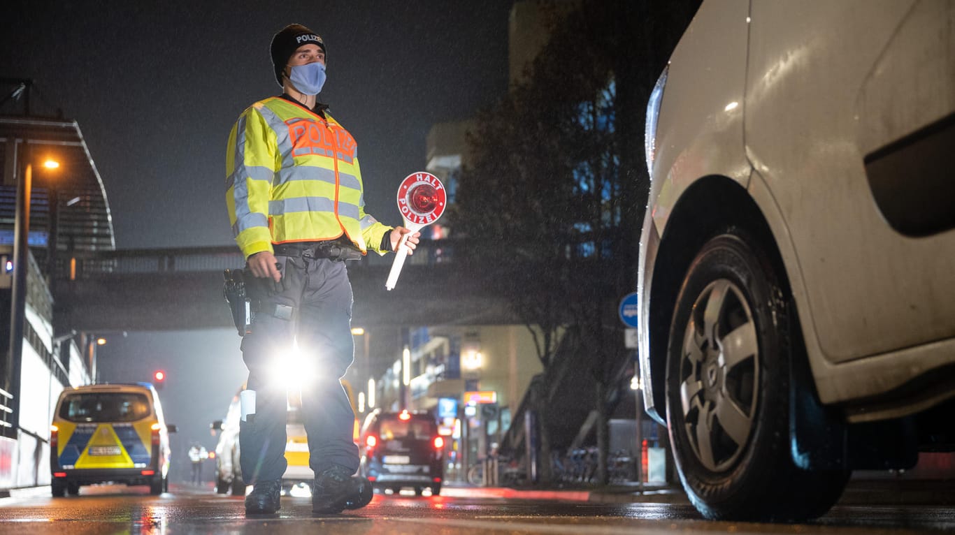 Stuttgart: Ein Polizeibeamter winkt während einer Verkehrskontrolle zur Einhaltung der coronabedingten Ausgangsbeschränkungen ein Auto raus.