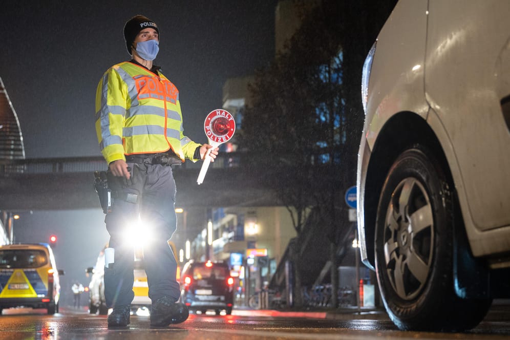 Stuttgart: Ein Polizeibeamter winkt während einer Verkehrskontrolle zur Einhaltung der coronabedingten Ausgangsbeschränkungen ein Auto raus.
