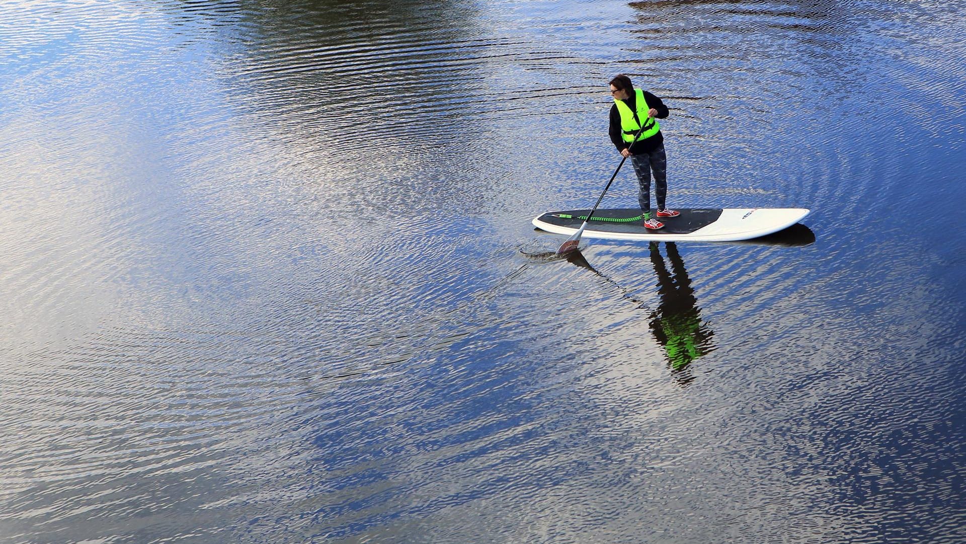 Stand-Up-Paddler auf einem Fluss (Symbolbild); Polizisten haben den 61-jährigen von seinem Brett geholt. Stand-Up-Paddler auf einem Fluss (Symbolbild); Polizisten haben den 61-jährigen von seinem Brett geholt.