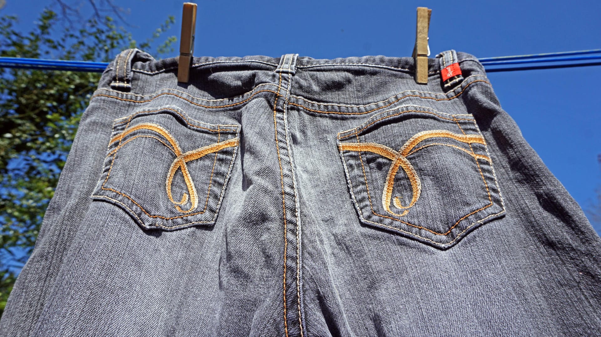 Jeans trocknen: Die Hose kann an der Luft trocknen – aber nicht direkt in der Sonne.