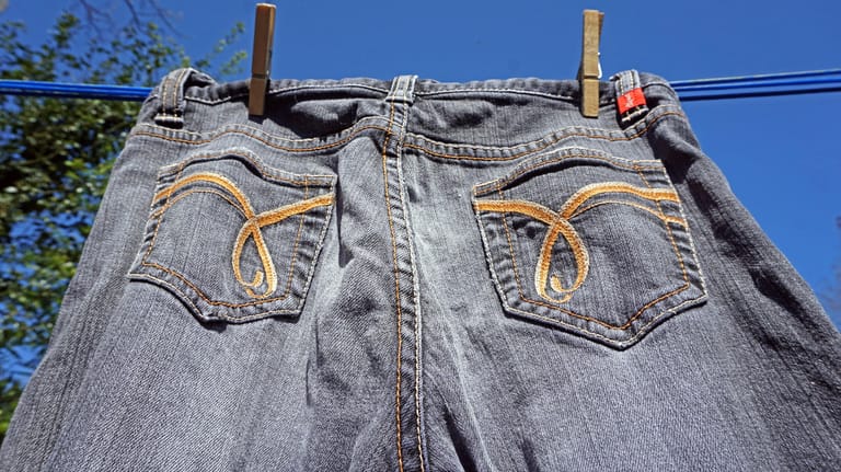 Jeans trocknen: Die Hose kann an der Luft trocknen – aber nicht direkt in der Sonne.