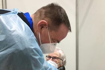 Ein Impfarzt spritzt eine Hagenerin ein Corona-Impfstoff: Als eine der Ersten ließ sich Karin Thikötter (81) im Hagener Impfzentrum impfen.