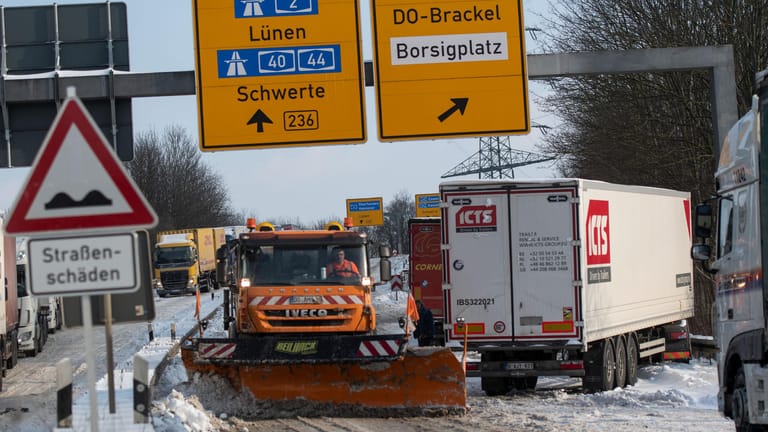 Ein Schneepflug ist auf einer Auffahrt zur B236 unterwegs, an deren Steigung sich mehrere Lastwagen quer gestellt haben: Wegen der Glätte wurden bereits kleine Steigungen zur Herausforderung für Kraftfahrzeuge.