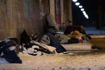 Obdachlose haben bei eisigen Temperaturen und Schnee unter einer Brücke ihr Lager errichtet (Archivbild): Die Stadt Mainz will Obdachlosen bei der Kälte mehr Angebote bieten.