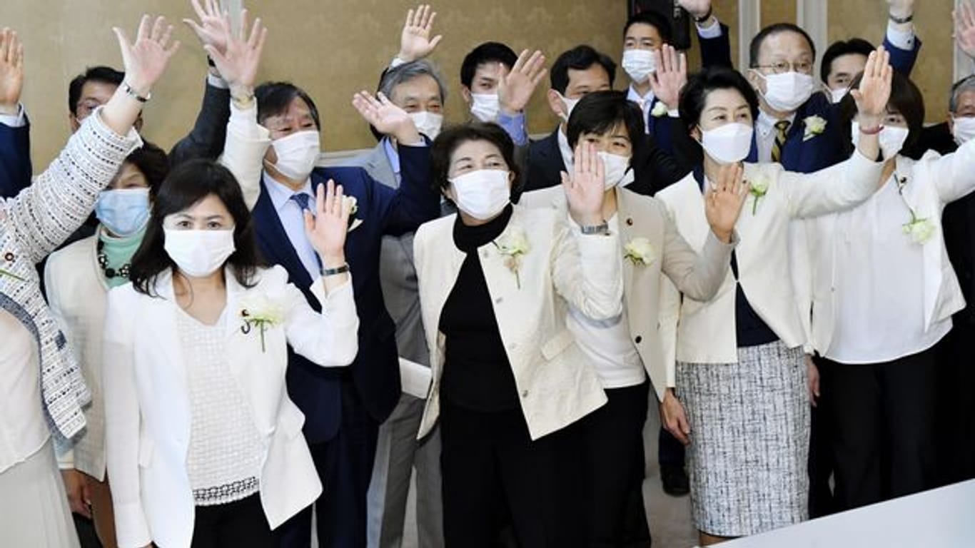 Weibliche Abgeordnete der Opposition tragen weiße Jacken mit weißen Rosen als Protest gegen sexistische Äußerungen von OK-Chef Mori.