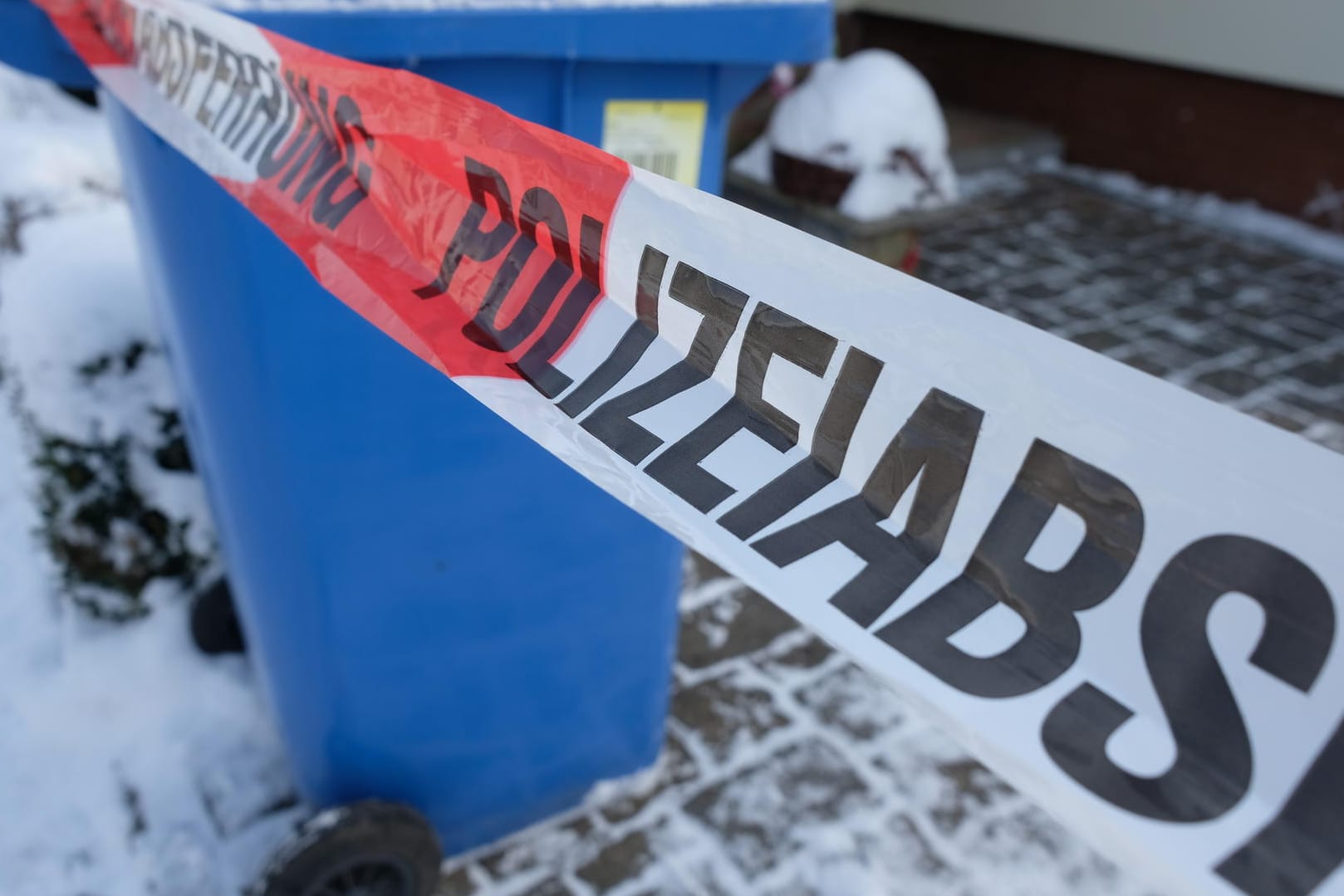 Absperrband umgibt ein Haus in Rödlitz im Landkreis Zwickau: In der Garage wurden die beiden Leichen gefunden.