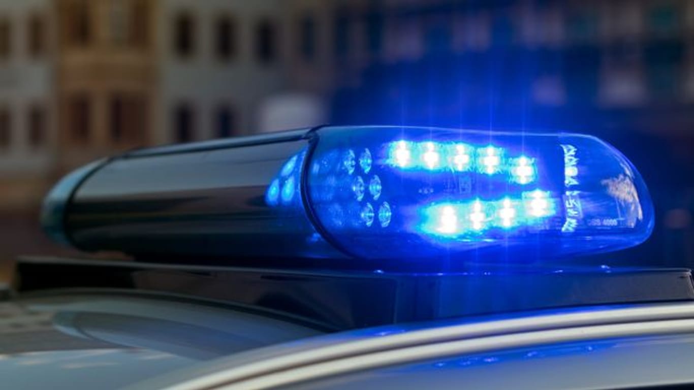 Ein Blaulicht leuchtet auf einem Polizeifahrzeug: Unbekannte haben einen Supermarkt überfallen.