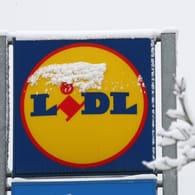 Das Logo eines Lidl-Supermarkts ist verschneit (Symbolbild): In Hagen wollten zwei Männer den Discounter mit einer Machete überfallen.