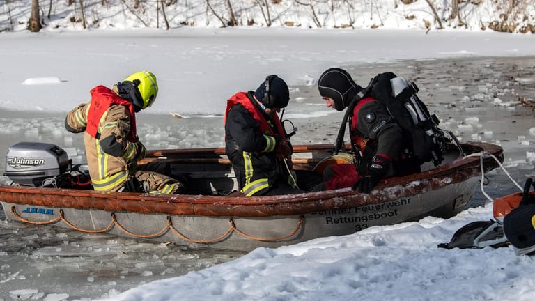 Einsatzkräfte der Feuerwehr bereiten sich auf einen Einsatz im Karpfenteich im Treptower Park vor: Dort waren nach ersten Informationen drei Männer zum Baden in ein Eisloch gestiegen.