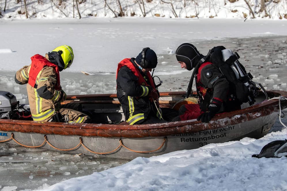Einsatzkräfte der Feuerwehr bereiten sich auf einen Einsatz im Karpfenteich im Treptower Park vor: Dort waren nach ersten Informationen drei Männer zum Baden in ein Eisloch gestiegen.