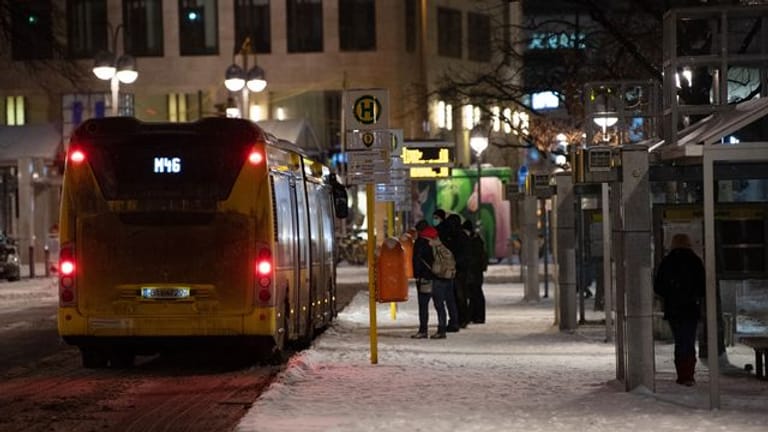 Reisende stehen an einer Bushaltestelle (Symbolbild): Wegen des Wintereinbruchs sind einige Verbindungen im ÖPNV ausgefallen.