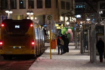Reisende stehen an einer Bushaltestelle (Symbolbild): Wegen des Wintereinbruchs sind einige Verbindungen im ÖPNV ausgefallen.