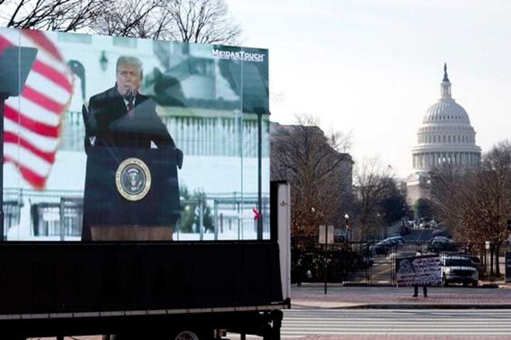 Der damalige US-Präsident Trump spricht zu seinen Anhängern: Auf einem Monitor in Washington wird eine Szene vom 6.