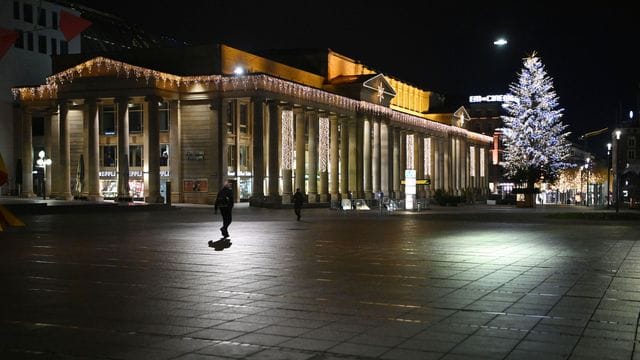 Ein Mann geht während der nächtlichen Ausgangssperre über den Schlossplatz in Stuttgart (Archivbild): Die Sperre gilt ab sofort für Kreise mit einer Inzidenz über 50.