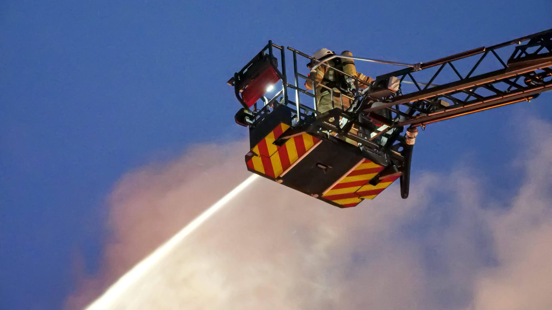 Einsatzkräfte der Feuerwehr in dem Korb auf einer Drehleiter (Symbolbild): Das Dach der Häuser musste teilweise abgedeckt werden. Einsatzkräfte der Feuerwehr in dem Korb auf einer Drehleiter (Symbolbild): Das Dach der Häuser musste teilweise abgedeckt werden.
