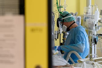 Ein Intensivpfleger versorgt auf der Covid-19 Intensivstation (ITS) im Städtischen Klinikum Dresden einen Corona-Patienten.