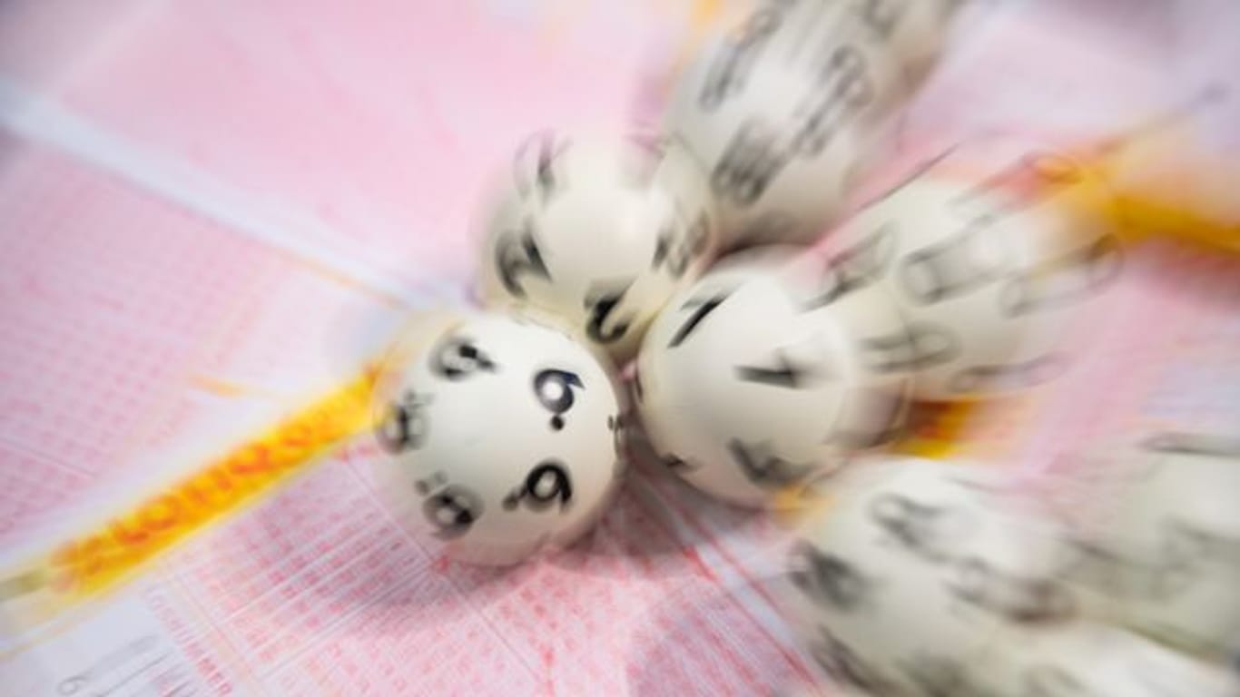 Lotto-Kugeln liegen auf einem Lottoschein (Symbolbild): Eine Frau aus dem Kreis Karlsruhe hat richtig getippt.