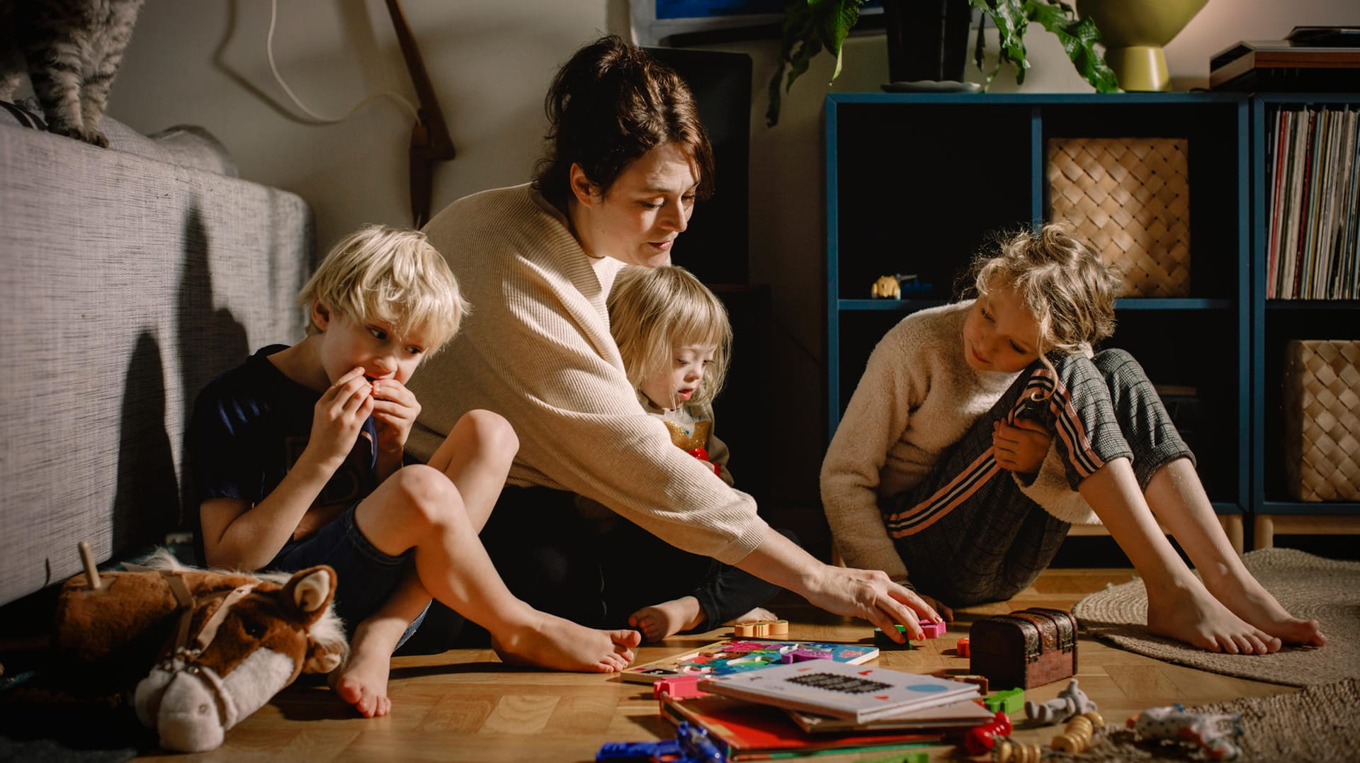 Eine Mutter spielt mit ihren Kindern (Symbolbild): Noch immer stecken häufig die Frauen beruflich zurück.