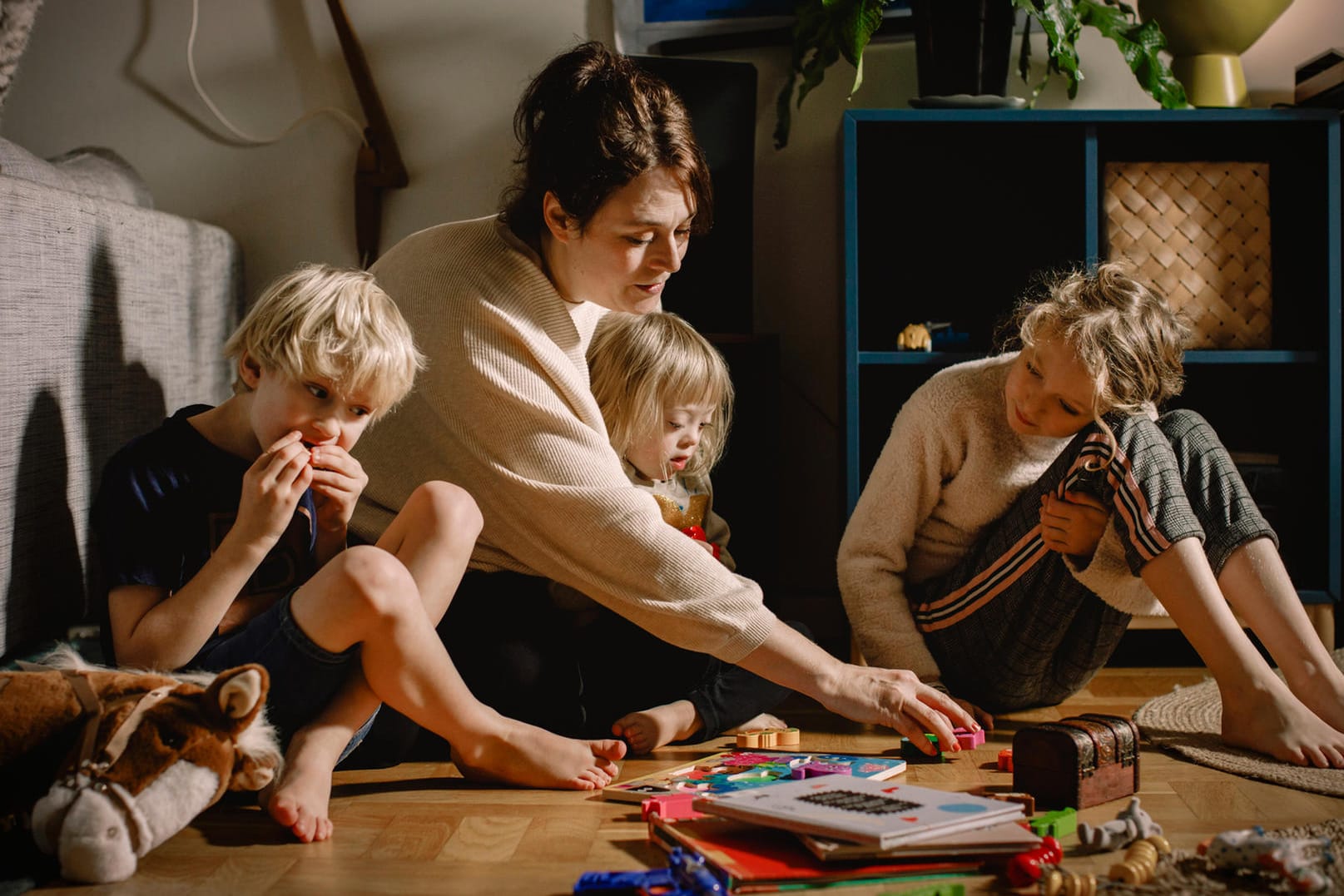 Eine Mutter spielt mit ihren Kindern (Symbolbild): Noch immer stecken häufig die Frauen beruflich zurück.