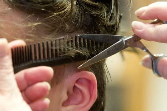 Eine Friseurin schneidet die Haare einer Kundin (Symbolbild): Die angekündigte Öffnung der Friseursalons hat einen Run auf Termine ausgelöst.