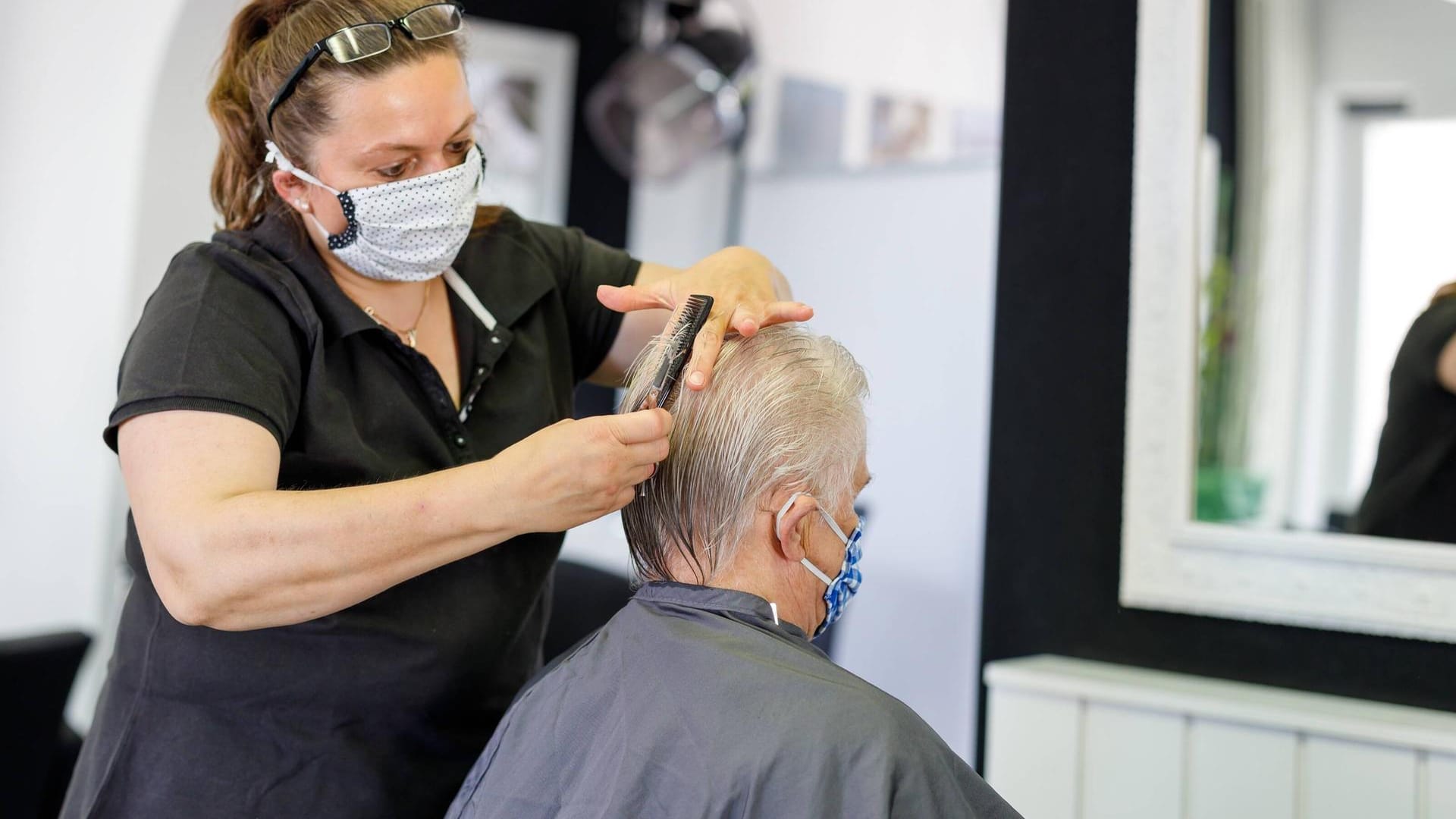 Friseurin und älterer Kunde: Viele Ältere kamen vor dem Lockdown regelmäßig nur zum Haarewaschen zum Friseur.