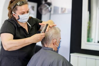 Friseurin und älterer Kunde: Viele Ältere kamen vor dem Lockdown regelmäßig nur zum Haarewaschen zum Friseur.