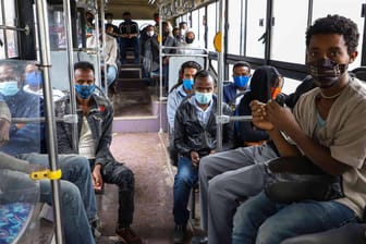 Menschen mit Schutzmasken sitzen in Addis Ababa (Äthiopien) in einem Bus: In vielen Ländern auf dem afrikanischen Kontinent gibt es bislang keinen Impfstoff.