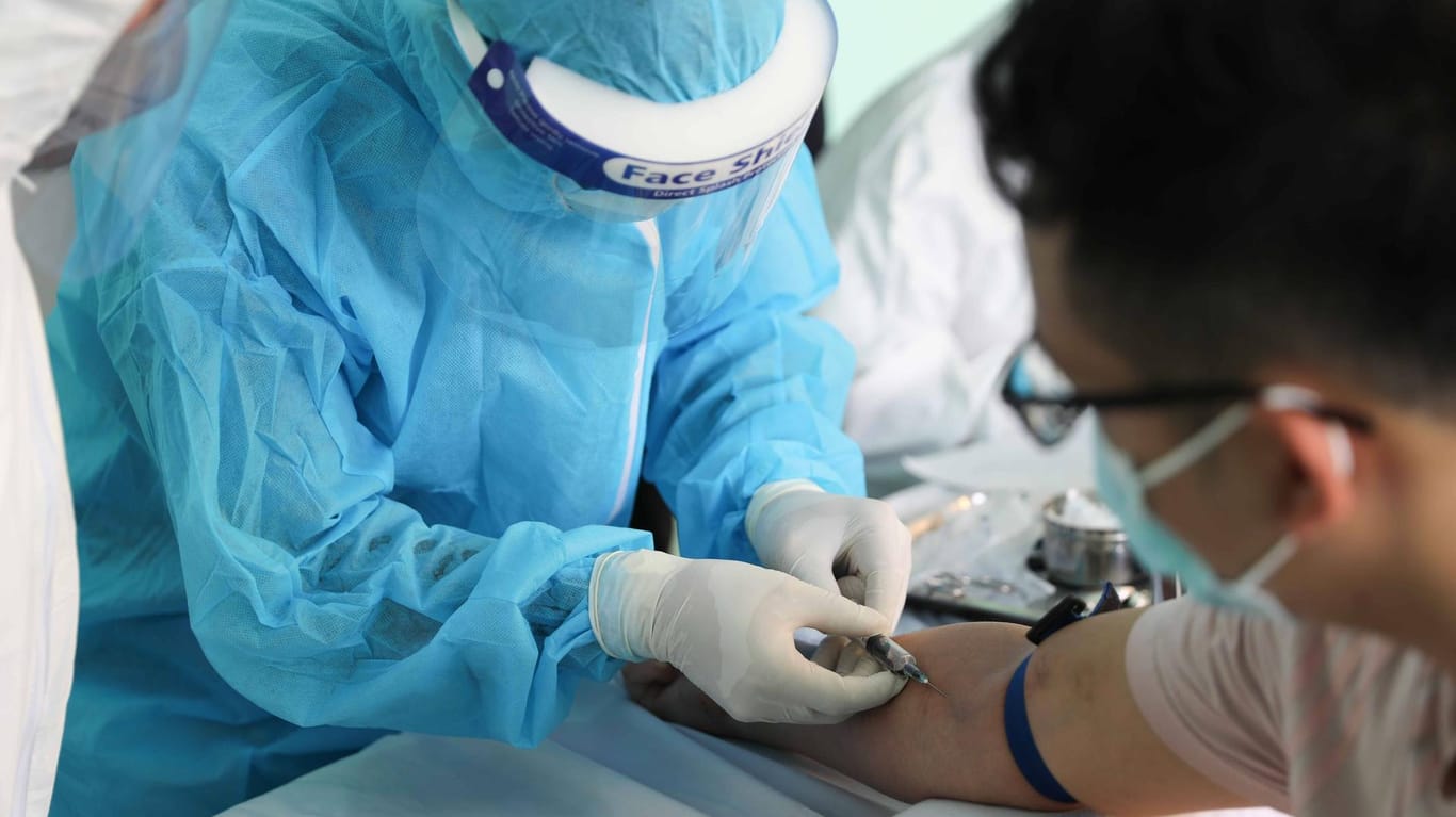 Hanoi (Vietnam): Einem Mann wird für einen Corona-Test Blut abgenommen.