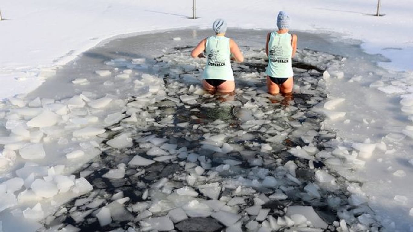 Zwei Frauen steigen in das eisige Wasser: Der Eisbade-Verein "Berliner Seehunde" rät zur langsamen Eingewöhnung.