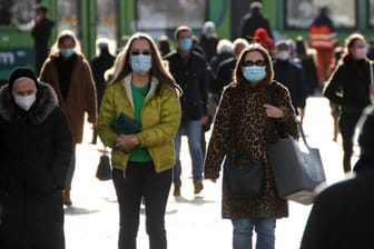 Menschen mit Maske laufen durch die Innenstadt: Seit etwa einer Woche sinken die Neuinfektionen fast täglich.