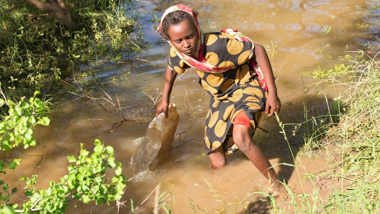 Ein Mädchen schöpft in Äthiopien Wasser: Mit dem neuen Entwurf des Lieferkettengesetzes soll Kinderarbeit eingedämmt werden.